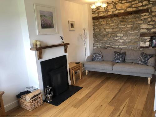a living room with a couch and a fireplace at Riccal Dale Cottage in Helmsley