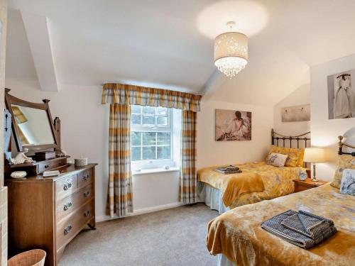 a bedroom with two beds and a dresser and a window at 2 Bed in Consett oc-96375 in Hunstanworth
