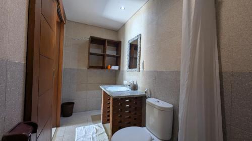 a bathroom with a toilet and a sink at Werkudara Guest House in Ubud