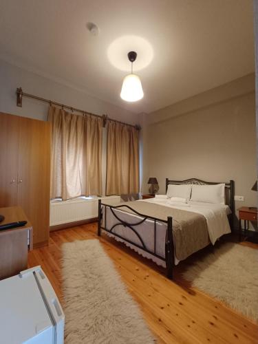 a bedroom with a large bed and a rug at Traditional Guesthouse Vrigiis in Agios Germanos