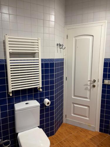 a bathroom with a toilet and a blue tiled wall at Ático centro Benicasim in Benicàssim