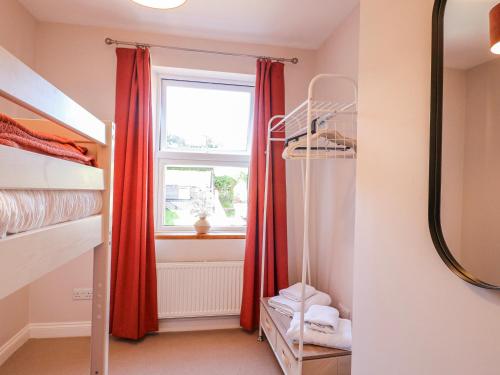 a bedroom with bunk beds and a window at Hill View Cottage in Ashbourne