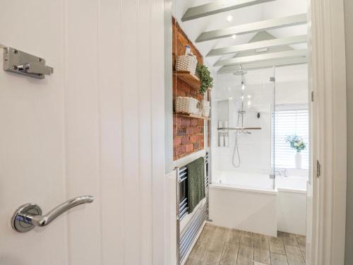 a bathroom with a brick fireplace next to a sink at Hill View Cottage in Ashbourne