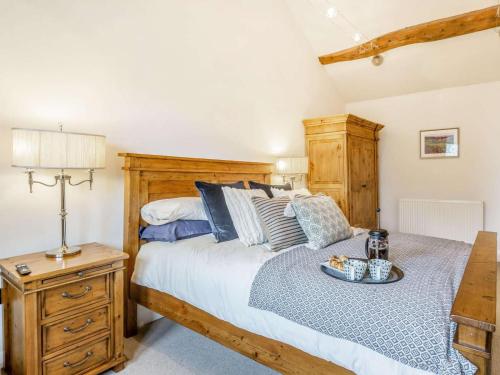 a bedroom with a wooden bed with a tray on it at 3 Bed in Keighley oc-89528 in Haworth