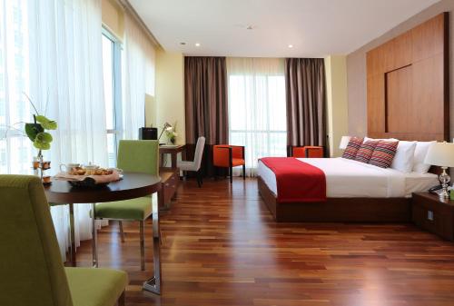 a hotel room with a bed and a desk and a table at Ramada by Wyndham Downtown Dubai in Dubai