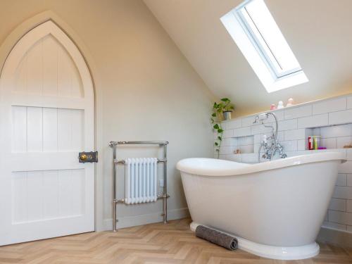a white bath tub in a bathroom with a skylight at 1 Bed in Ripon oc-95074 in Dishforth