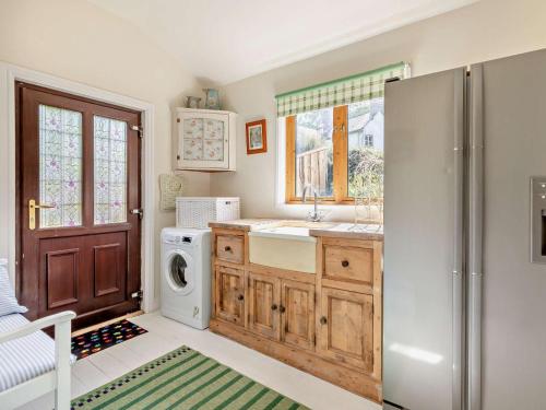 a kitchen with a refrigerator and a washing machine at 3 Bed in Watchet oc-95161 in Washford