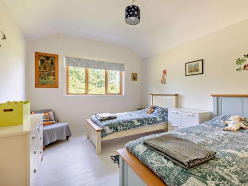 a bedroom with two beds and a window at 3 Bed in Watchet oc-95161 in Washford