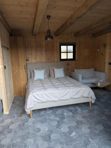 a bedroom with a large bed and a couch at Onder de Oude Walnoot in Sint Pancras