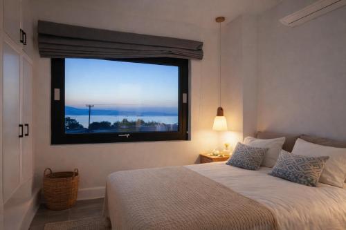 a bedroom with a bed and a large window at Villa Andalusia, Steps from Orkos Beach in Naxos Chora