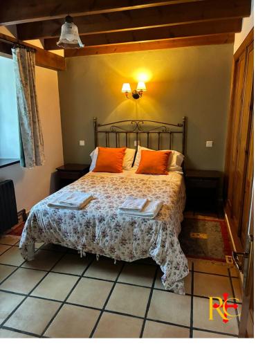 a bedroom with a bed with orange pillows on it at rincón de covadonga in Caño