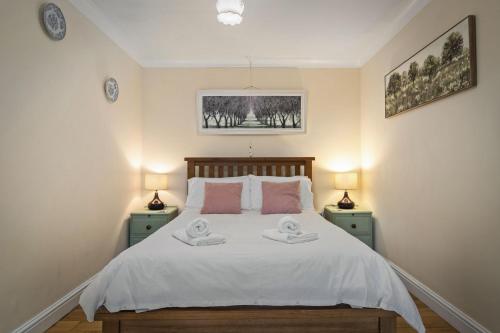 a bedroom with a bed with two towels on it at Ffynnonlwyd Cottage - rural holiday cottage with hot tub in Llangynin
