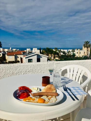 a plate of food on a table with a view of the ocean at 260 m to Beach, Sea&Sunset view terrasa in Khlorakas