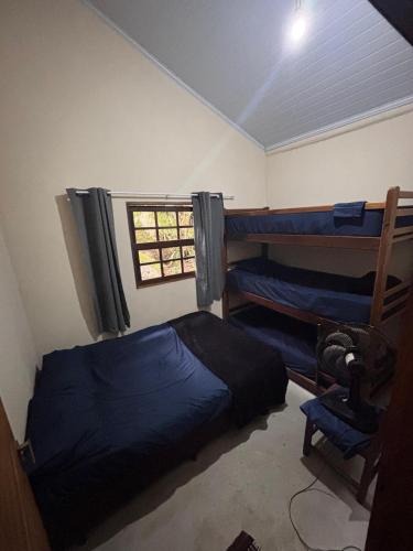 a room with two bunk beds and a window at Casa na Mata - 2 min da Praia de fora com WiFi in Paraty