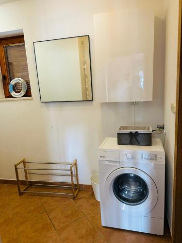 a washing machine in a room with a mirror at Apartment ADEPTO in Sveti Jakov