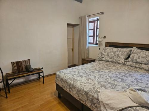 a bedroom with a bed and a chair and a window at Quinta Adela Bed & Breakfast in San Pedro de Atacama