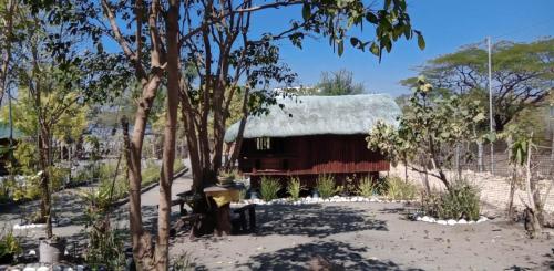 a barn with a thatched roof in a forest at Cristy's Relaxing Sunny Place in Rimus