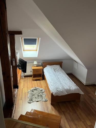 a bedroom with a bed and a tv in a attic at Conacul Maria in Ocna-Mureşului