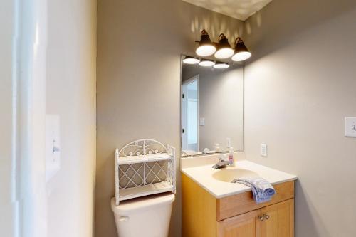 a bathroom with a sink and a mirror and a toilet at Rylander-Timmerman House OBX in Nags Head