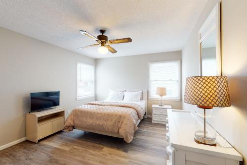 a bedroom with a bed and a ceiling fan at Rylander-Timmerman House OBX in Nags Head