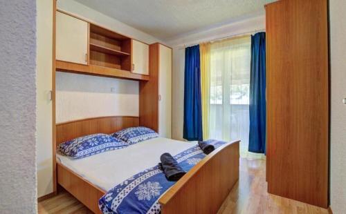 a bedroom with a large bed with blue pillows at Apartments Velebit house in Biljevine