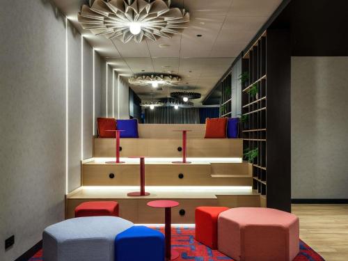a waiting area with colorful stools in a room at Hotel Ibis Krakow Centrum in Krakow