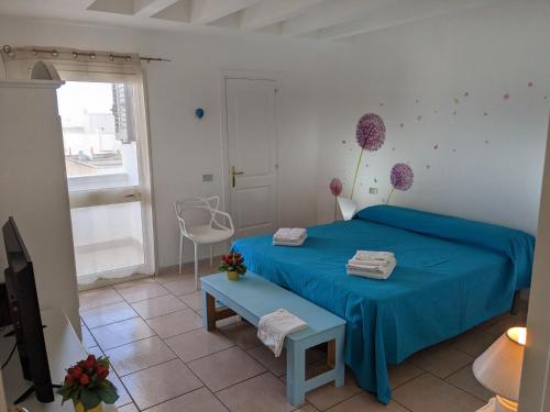 a bedroom with a blue bed and a table at B&B Casa De Mare in Lido Marini