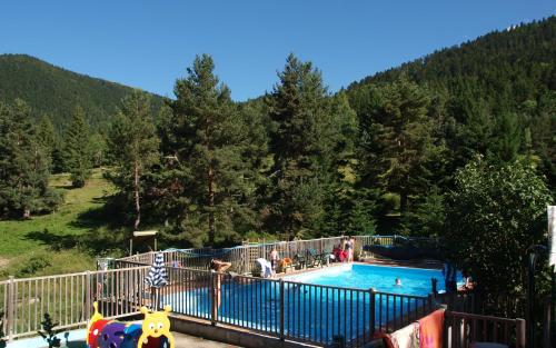 a large swimming pool with people in a mountain at Lodge Holidays - Les Sapins in Camurac