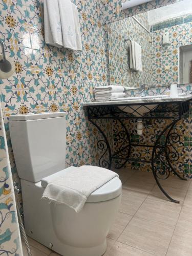 a bathroom with a toilet and a sink at Hôtel Bou Fares in Sidi Bou Saïd