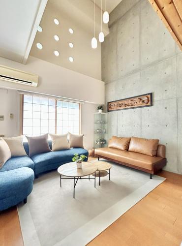 a living room with two couches and a table at Grand Reve KODEKI Near Nagoya Dome in Yadachō