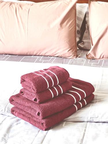 a pile of towels sitting on top of a bed at LECAR Home Shelby in Ban Nong Khang