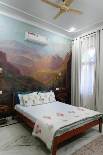 a bedroom with a bed with a painting on the wall at Otla - A Heritage Boutique Hotel, Jaipur in Jaipur