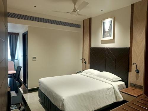 a hotel room with a bed and a desk at Crystal Residency - Panjappur Trichy in Pūngudi