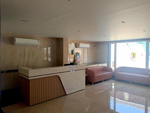 a living room with a counter and a pink couch at Crystal Residency - Panjappur Trichy in Pūngudi