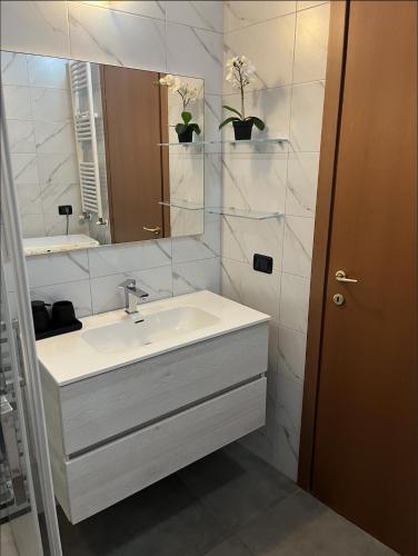 a white bathroom with a sink and a mirror at COZY LAKE COMO APARTMENTS in Valmadrera
