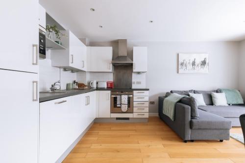 a living room with a couch and a kitchen at Contemporary 1BD Flat - Bristol City Centre! in Bristol