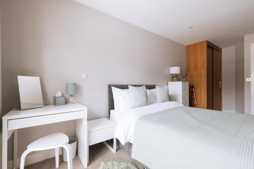 a white bedroom with a bed and a desk at Contemporary 1BD Flat - Bristol City Centre! in Bristol