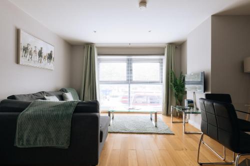 a living room with a couch and a large window at Contemporary 1BD Flat - Bristol City Centre! in Bristol
