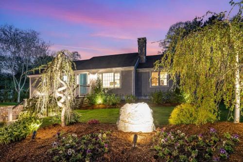 a home with a large tree in the yard at Beachside family POOLSPAOPEN20thAPril in Barnstable