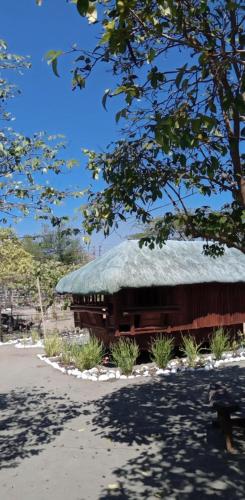a building with a thatched roof with a tree at Cristy & Ashley's Sunny Place in Rimus