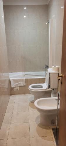 a bathroom with a toilet and a bath tub at Descanso, Mar & Conforto in Esposende