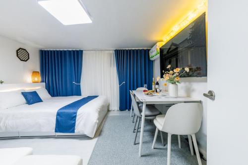 a hotel room with a bed and a table and chairs at 홍대 stay yoo - Hongdae 3min Station Cozy House in Seoul