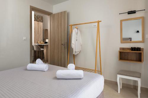 a bedroom with a bed with two towels on it at Drakos Estate - Luxury Pool Villas in Asgourou