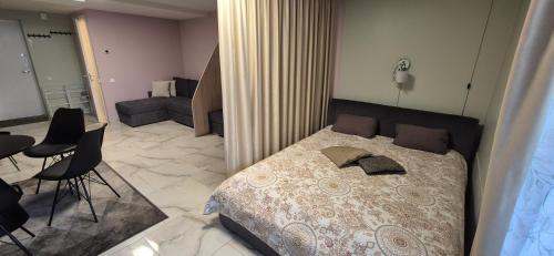a bedroom with a bed and a living room at Apartamentai Gintaras in Palanga