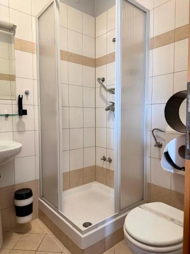 a shower stall in a bathroom with a toilet at Tamaris Rooms in Zadar