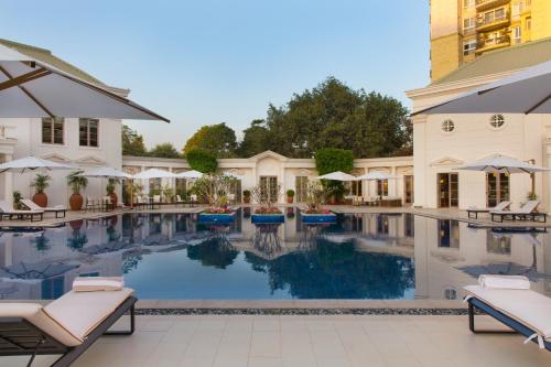 a pool at a hotel with chairs and umbrellas at DLF Club 4 in Gurgaon