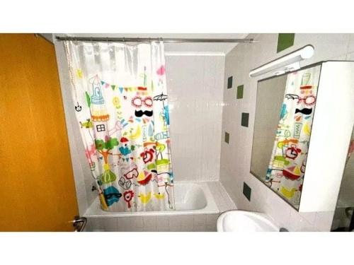 a bathroom with a toilet and a shower curtain at Apartamento Summer Place in Monte Gordo