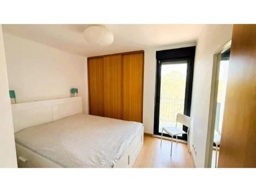 a bedroom with a bed and a window and a chair at Apartamento Summer Place in Monte Gordo