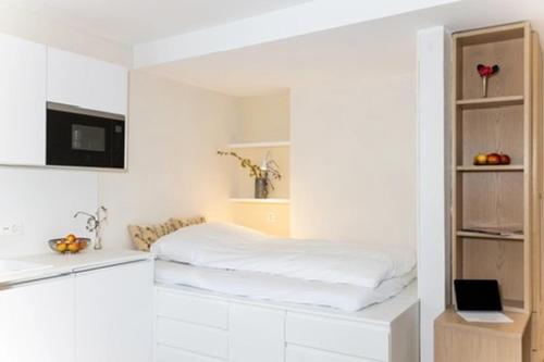 a white room with a bed and a sink at Herti14 Serviced Apartments in Ennetbaden