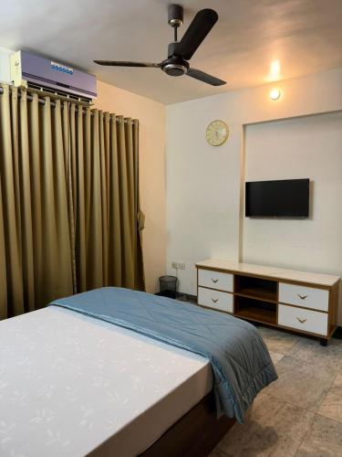 a bedroom with a bed and a flat screen tv at Divine Abode in Thane